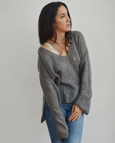 Woman wearing oversized grey mohair knitted V neck sweater and jeans